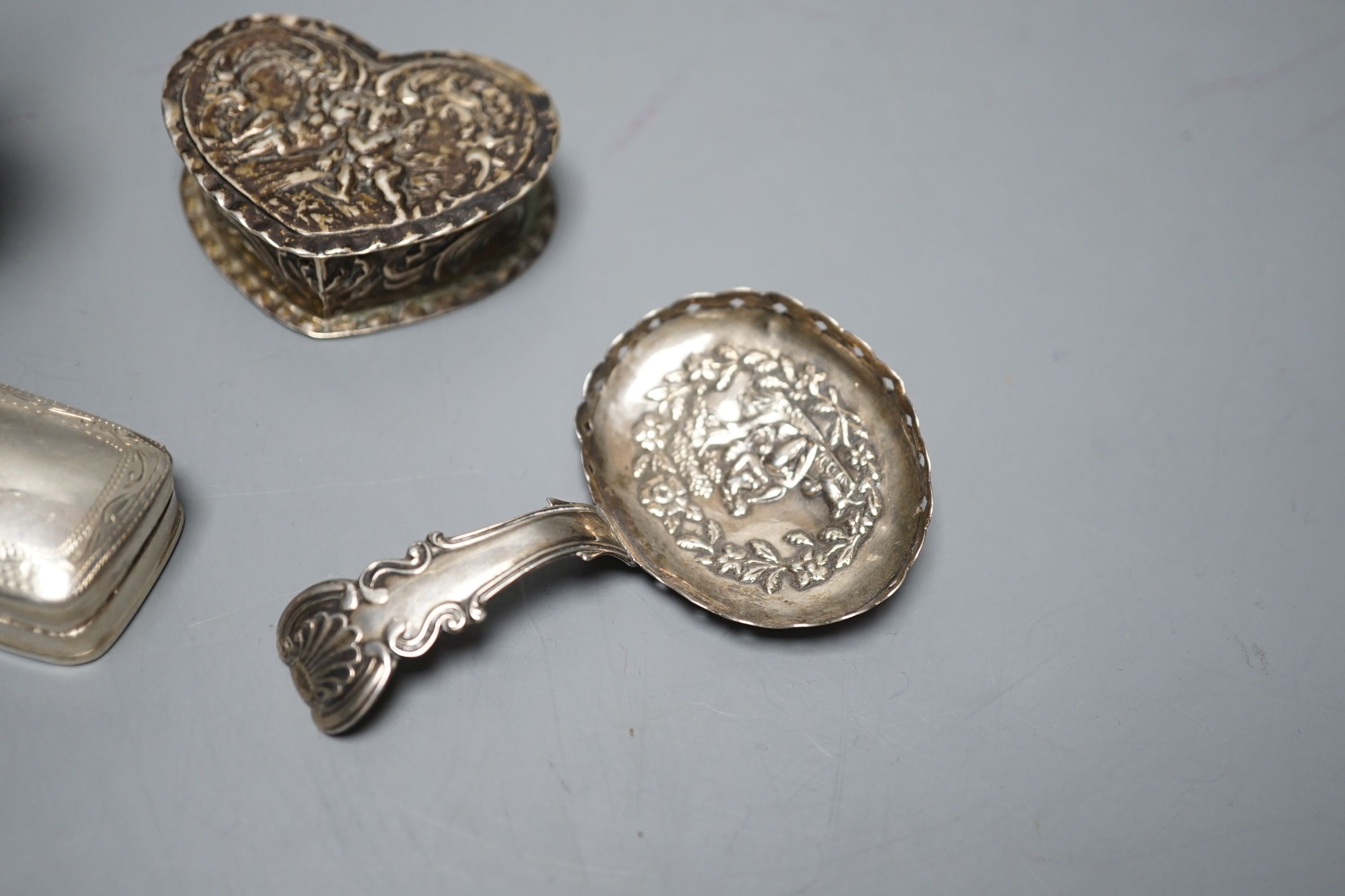 A George III silver caddy spoon, with associated bowl, handle marked for John Bettridge, Birmingham, 1817, 76mm, a late 19thcentury Hanau white metal small jug, an embossed white metal heart shape box and a white metal p